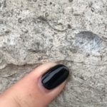 finger pointing to brachiopod fossil in stone house